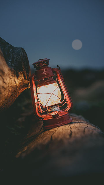 A lit oil lamp in a dark night